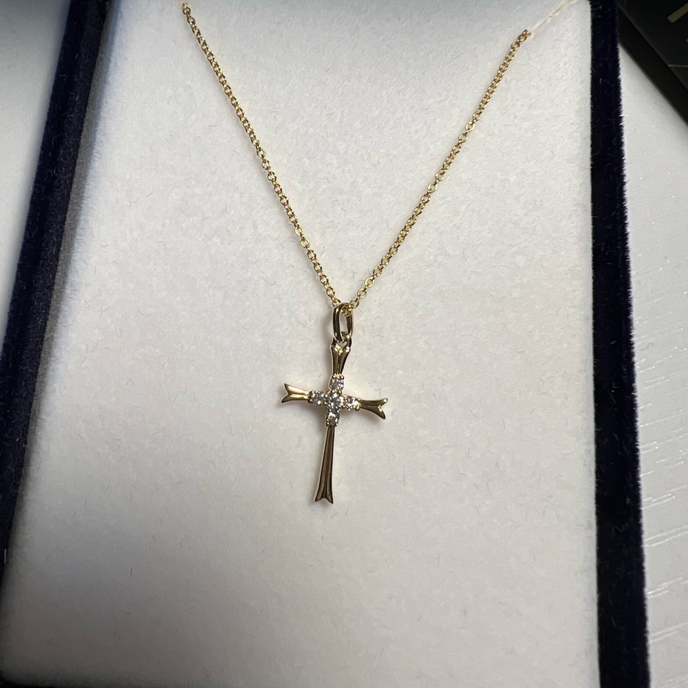 14K solid gold cross on a 16’’ chain with four diamonds in the middle.